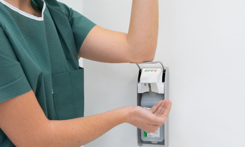 Pflegepersonal führt hygienische Händedesinfektion mit einem alkoholischen Händedesinfektionsmittel durch